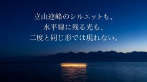 夜明け前の海に浮かぶ立山連峰のシルエットと水平線の光